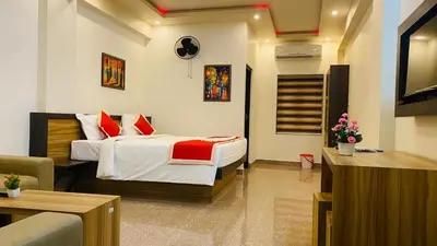 a bedroom with a bed and a living room at POOJA inn in Guruvāyūr