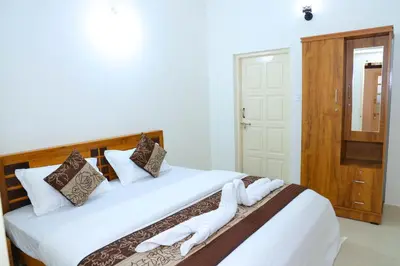 a bedroom with two beds with white sheets at Coorg Lotus Villa in Madikeri
