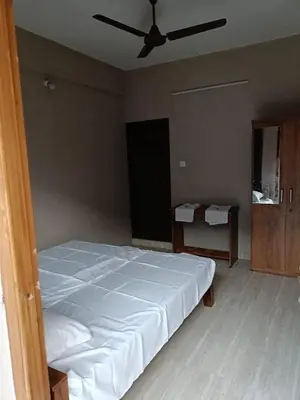 a bedroom with a bed and a ceiling fan at MB Arcade in Tellicherry