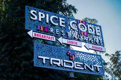 a sign for a theatre with street signs on it at Trident in Ooty