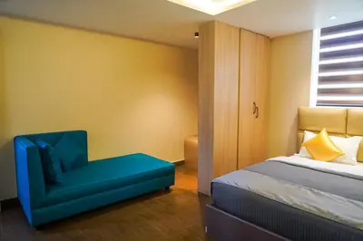 a bedroom with a bed and a blue chair at Trident in Ooty