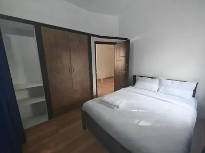 a bedroom with a large white bed and a closet at Urban Nest Residence in Mysore