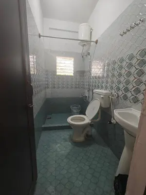 a bathroom with a toilet and a sink at Urban Nest Residence in Mysore