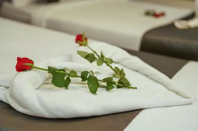 a red rose on a towel on a table at Royal Plaza City in Kozhikode