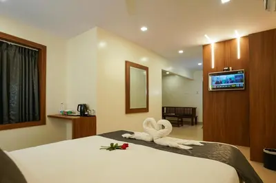 a room with a bed with a towel animal on it at Royal Plaza City in Kozhikode