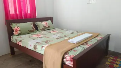 a bed with a laptop on top of it at AYYAN RESIDENCY in Alāndurai