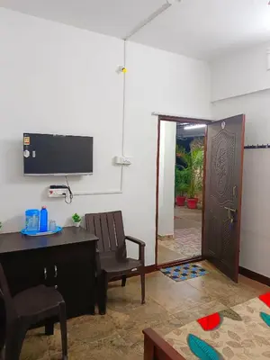 a room with a desk and a chair and a door at AYYAN RESIDENCY in Alāndurai