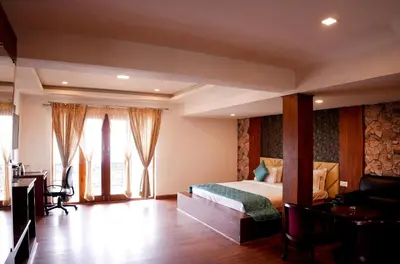 a bedroom with a bed and a desk in a room at Vista Sunrise Resort Ooty Dodabetta in Ooty