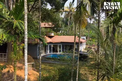 a house with a swimming pool in the middle of trees at StayVista at Palm Tree Homes with Complimentary Breakfast, BBQ Grill and Pet-Friendly Home in Wayanad