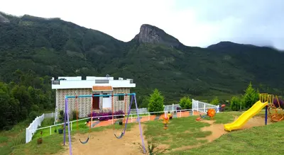 a playground in front of a building with a slide at Vrindhavan Mist City Resorts in Kanthalloor