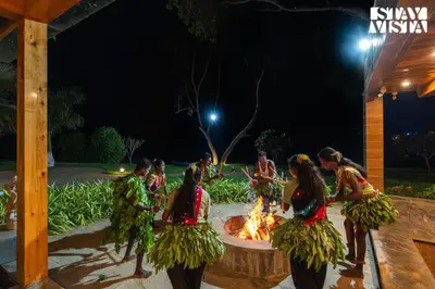 a group of women dancing around a fire at night at StayVista at Exotica Kabini - All Meals Included - Riverfront Villa in Antarasante
