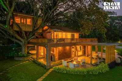 a large house with a tree in the yard at StayVista at Exotica Kabini - All Meals Included - Riverfront Villa in Antarasante