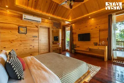 a bedroom with a bed and a tv in a room at StayVista at Exotica Kabini - All Meals Included - Riverfront Villa in Antarasante