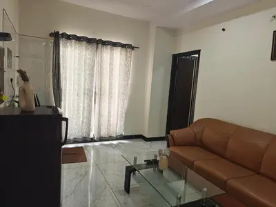 a living room with a couch and a glass table at The Whispering Willows in Mysore