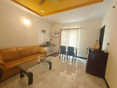 a living room with a couch and a table at The Whispering Willows in Mysore