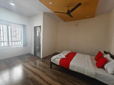 a bedroom with a bed with a ceiling fan at The Whispering Willows in Mysore