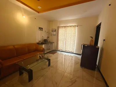 a living room with a couch and a table at The Whispering Willows in Mysore