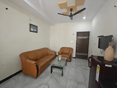 a living room with a couch and a tv at The Whispering Willows in Mysore