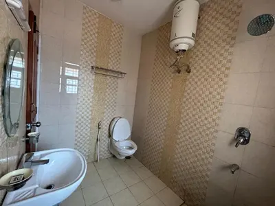 a bathroom with a toilet and a sink and a shower at Madhu Manish Homestay and Rooms in Coonoor