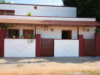 a house with red and white garage doors at Vigneshwara Nilaya in Mysore