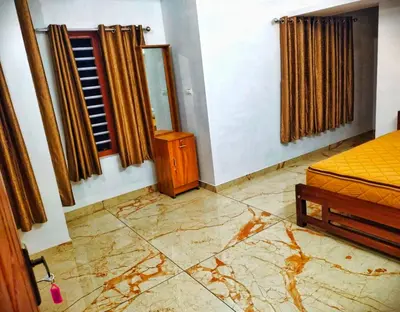 a bedroom with a bed and a mirror and a window at Centre Home Homestay Wayanad in Kalpetta