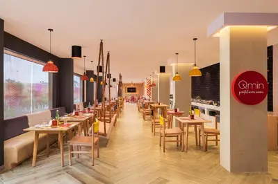 a restaurant with tables and chairs in a room at Ginger Coimbatore Airport , Avinashi Road in Coimbatore