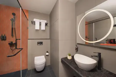 a bathroom with a toilet and a sink and a mirror at Ginger Coimbatore Airport , Avinashi Road in Coimbatore