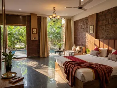 a bedroom with a bed and a living room at Udaya Resort in Palakkad