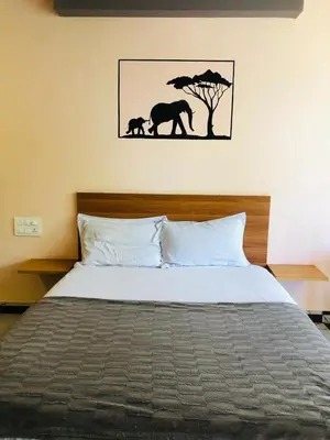 a bedroom with a bed with a picture of elephants at Udaya Resort in Palakkad