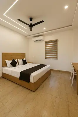 a bedroom with a bed and a ceiling fan at Grandstaykannur in Kannur