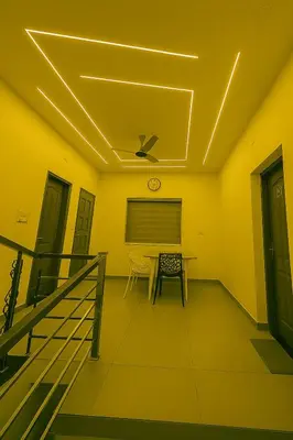 a dining room with a table and a ceiling at Grandstaykannur in Kannur