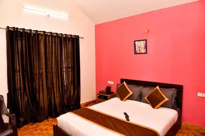 a bedroom with a bed with a red wall at Phoenix View Stay Ooty in Ooty