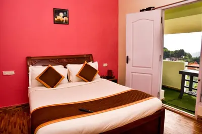 a bedroom with a bed with a red wall at Phoenix View Stay Ooty in Ooty