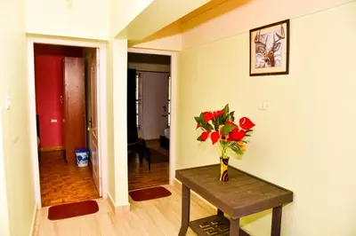 a room with a table with a vase of flowers on it at Phoenix View Stay Ooty in Ooty