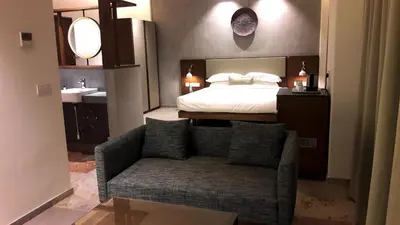 a bedroom with a bed and a couch and a sink at Sopanam Heritage in Guruvāyūr