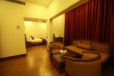 a living room with a couch and chairs and a bed at Sopanam Heritage in Guruvāyūr