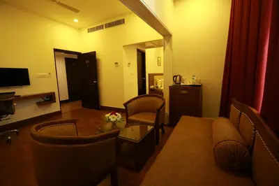 a living room with a couch and a table and chairs at Sopanam Heritage in Guruvāyūr