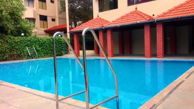 a swimming pool at a hotel with red tile roofs at Sopanam Heritage in Guruvāyūr