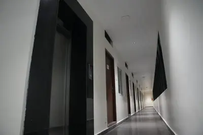 a hallway of a building with black and white walls at Goldeye's Inn in Erode