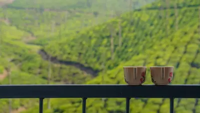 two coffee cups sitting on a ledge overlooking a mountain at Zen Vista in Vālpārai