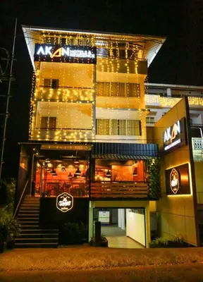 a tall building with lights in front of it at AKAN HOTEL AND RESIDENCE in Wayanad