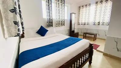 a bedroom with a bed with blue and white sheets at Misty Green Coorg in Madikeri