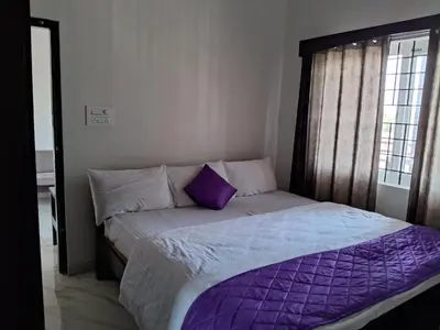 a bed with a purple comforter in a bedroom at Royal homes a1 in Kushālnagar
