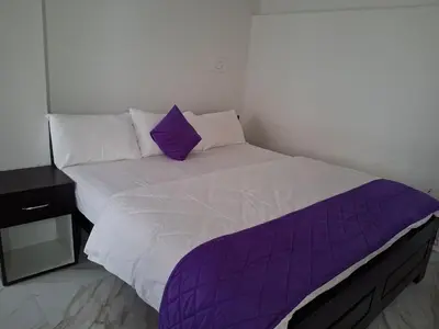 a bed with purple sheets and pillows in a room at Royal homes a1 in Kushālnagar