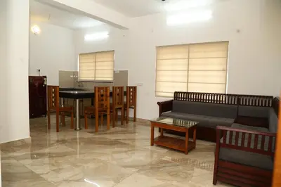 a living room with a couch and a table and chairs at Shoreline in Kozhikode