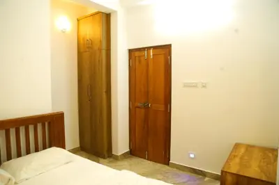 a bedroom with a bed and a wooden cabinet at Shoreline in Kozhikode