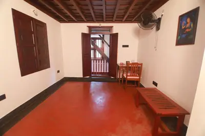 an empty room with a table and a door at Vilayara Heritage Retreat in Kunnamangalam