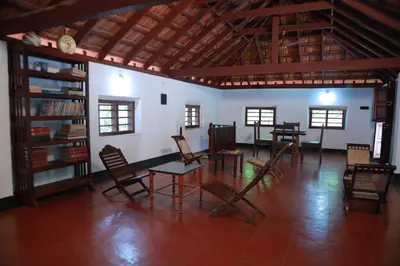 a room with a table and chairs in it at Vilayara Heritage Retreat in Kunnamangalam