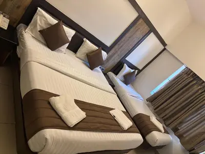 a bedroom with a large bed in a room at WESTLAND HOTEL- ERODE in Erode