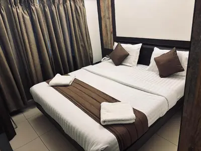 a bed with two pillows on it in a room at WESTLAND HOTEL- ERODE in Erode